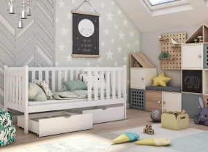 Hvid juniorseng med sengehest i indrettet børneværelse med legetøj, opbevaring og stjernevæg.