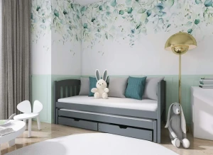 Mørkegrå trækudsseng i børneværelse med blade tapet, pude og kaninbamse.