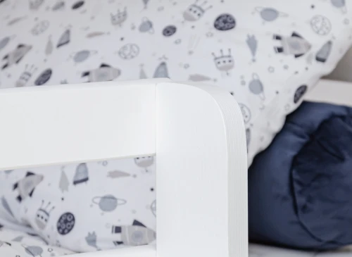 Nærbillede af hvid køjesengsramme med sengetøj med rumtema