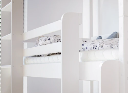 Hvid køjeseng med to senge og sengetøj med rumtema samt madrasser