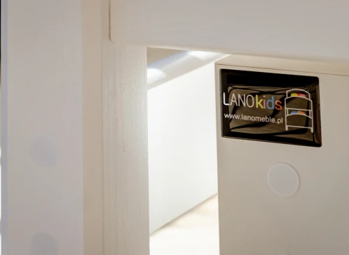 Nærbillede af hvid sengestel i træ med LANOkids logo og hjemmesideadresse.