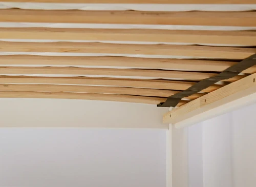 Detalje af sengerammer med trælameller til en robust og komfortabel børneseng.