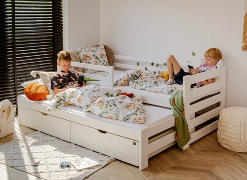 To drenge slapper af med mobiler på hvid udtræksseng. Moderne og praktisk daybed til børneværelset.