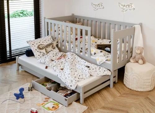 Lysegrå børneseng med udtræksseng og opbevaring. Børneværelse med legetøj, vindue og flylamper.