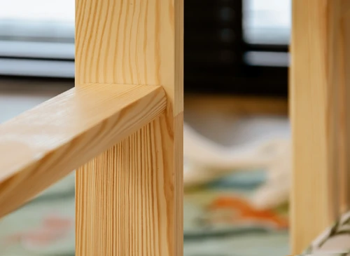Detalje af træsengsramme, der viser samling mellem vandret og lodret stolpe. Solidt trædesign.