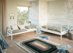 Børneværelse med to hvide enkeltsenge, grønne puder, og hav-tema tapet. Perfekt til søskende eller gæster.