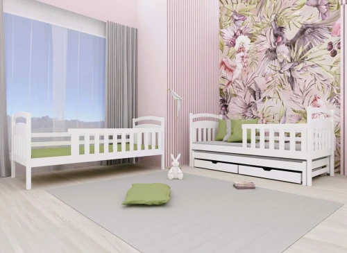 Hvide træsenge i børneværelse med grønne puder. Enkeltseng og udtræksseng med skuffer. Lyserøde vægge og blomstertapet.