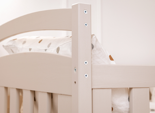 Detalje af køjesengs hjørnestolpe og sengegavl i lyst træ. Solid og sikker konstruktion.