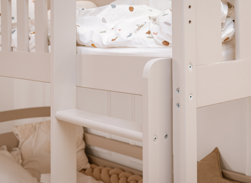 Detalje af køjesengs stige og sengekant i lyst træ. Sikker og stabil stige til børn.