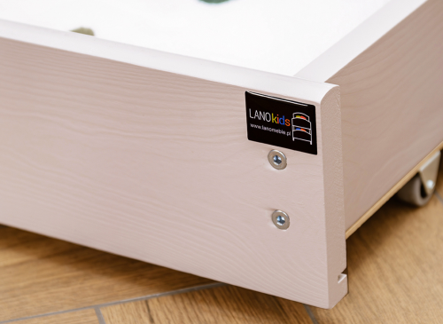 Nærbillede af udtrækssengens skuffe med LANOKids-logo og hjul, praktisk opbevaring.