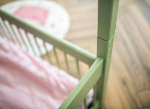 Nærbillede af den mintgrønne sengekant og lyserødt sengetøj. Kvalitetsdetaljer til børneværelset.