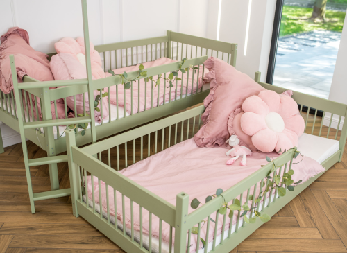 To grønne senge med lyserødt sengetøj og guirlander. Fleksible sengeløsninger til børneværelset.