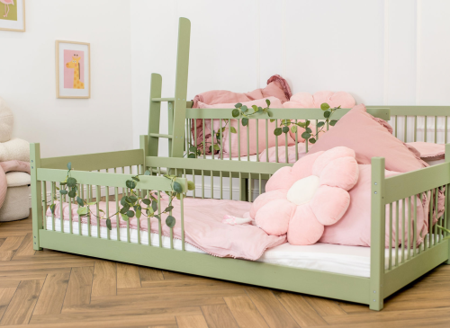 Grøn køjeseng med stige og enkeltseng, dekoreret med lyserødt og eukalyptusguirlander.