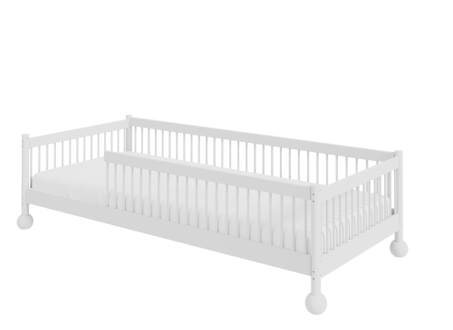 Hvid juniorseng med sengeside/sikkerhedsbarriere, set fra siden.