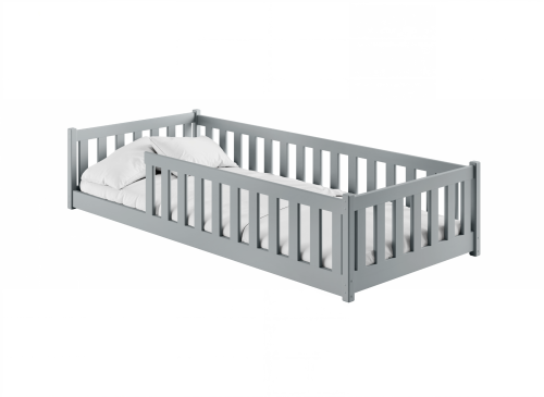 Grå juniorseng med sengehest og sengetøj.