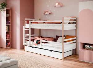 Hvid og naturtræ køjeseng med skuffer i et indbydende børneværelse med lyserøde nuancer.