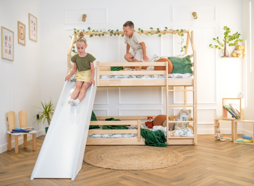 Børn leger på en hvid/træ køjeseng med rutsjebane i børneværelse. Glad pige og dreng på legeseng.