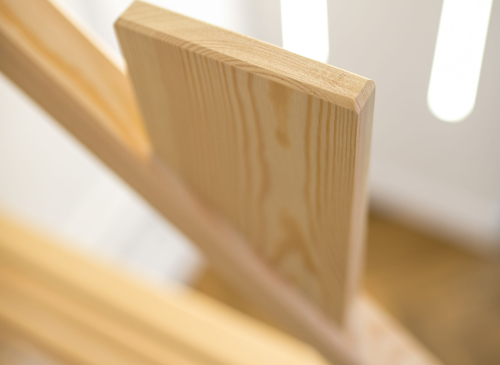 Nærbillede af lyst træ med tydelige årer fra en køjeseng.